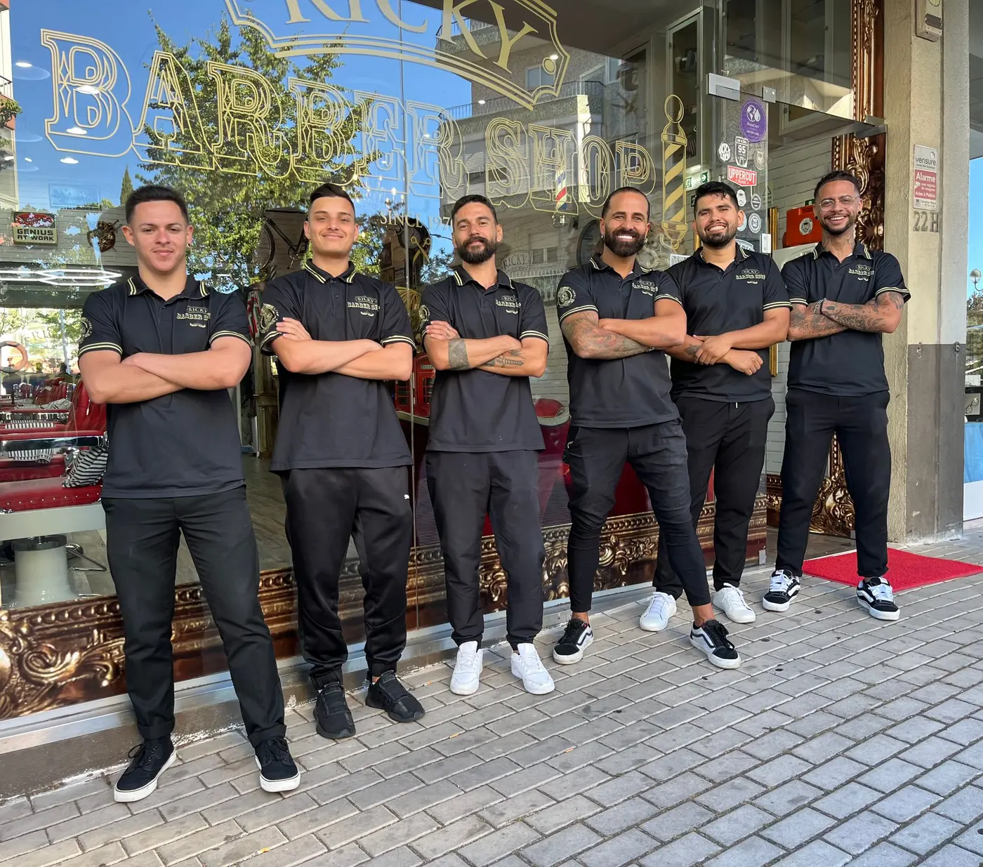 Equipa da Ricky Barber Shop à entrada da barbearia